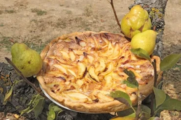 Une tarte aux poires et au chocolat est installée dans un poirier avec des poires autour